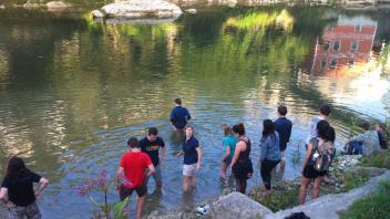 Students standing along a river.