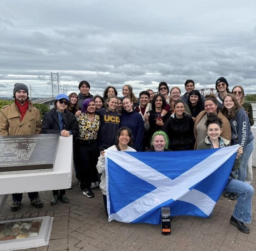 UC Davis student Anya Nygaard and her cohort as they hold up the national flag of Scotland