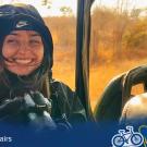 Student smiling in a vehicle with a camera, dry landscape in the background, and UC Davis Global Affairs branding at the bottom.