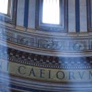 Photo on the inside of a large European building, with sun rays shining through the windows