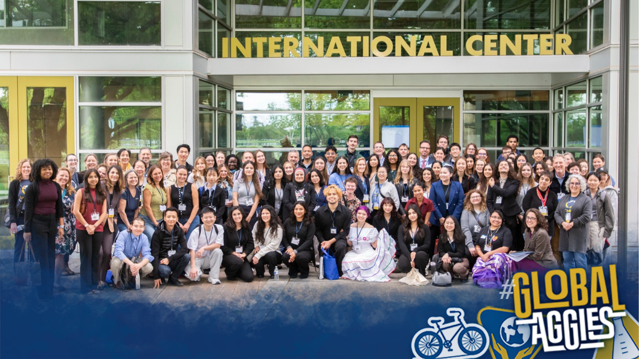 Large group outside International Center; Global Aggies logo visible