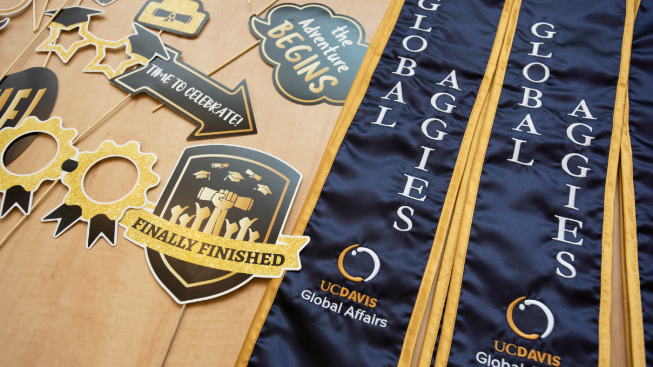 Decorative graduation items including awards, ribbons, and banners on a wooden surface.